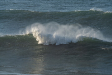 large waves breaking in the open ocean during a tropical storm