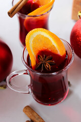 Mulled wine with orange slices, cinnamon sticks with Christmas balls