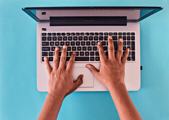 Manos de hombre escribiendo en teclado de laptop. aislado en fondo celeste