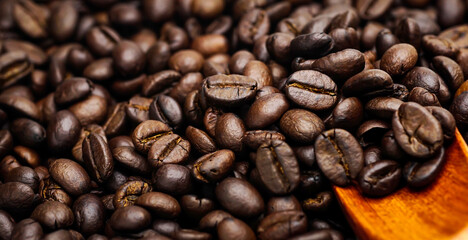 Coffee beans on a wooden spoon.	