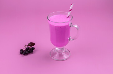 a glass of chokeberry cocktail on a pink background. the concept of healthy eating