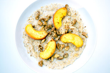 cinnamon oatmeal porridge hot healthy breakfast with peach slices and walnuts