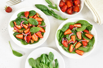 Fruit salad with strawberry and spinach in white bowl