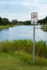 vertical image - no swimming sign in front of a small marsh in Florida park 