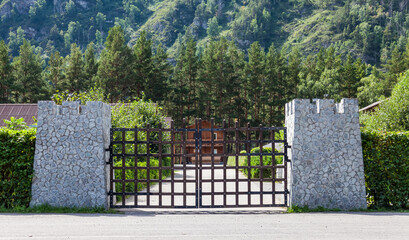 Stylized entrance to the recreation center through the castle gate with stone columns and iron bars...