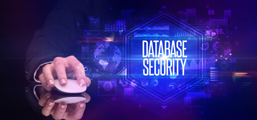 hand holding wireless peripheral with DATABASE SECURITY inscription, cyber security concept