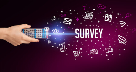 hand holding wireless peripheral with SURVEY inscription, social media concept