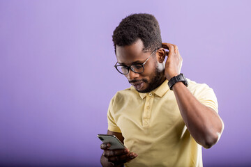 Young happy african man with cellphone isolated on lilac background