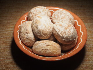 Gingerbread in a white sugar glaze lie in a brown clay Cup.