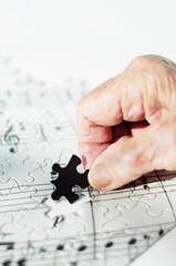 Elderly hand fits puzzle piece