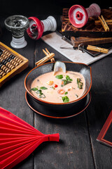 Asian seafood soup in a black bowl 