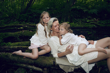 blonde mother with two children in a white dress