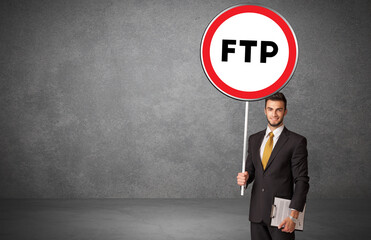 Young business person holdig traffic sign with FTP abbreviation, technology solution concept