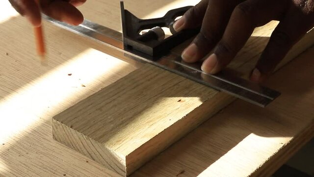 carpenter drawing a line with a pencil and combination square
