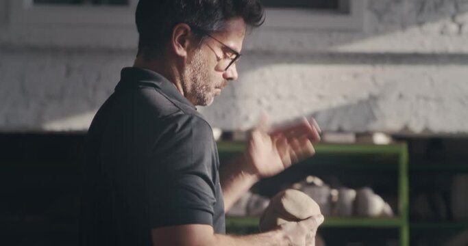 Male artisan slapping and kneading clay