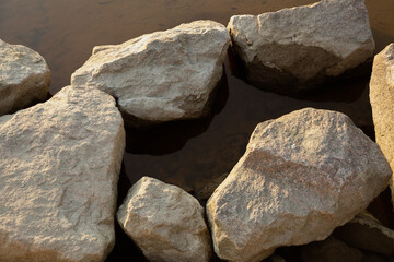 Cement stones in mirror-like water lit by the setting sun