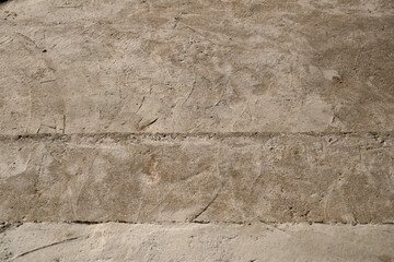 Close-up shot of a roughly finished concrete surface. Two parallel lines of joints