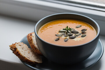pumpkin and carrot cream soup with pumpkin seeds and toasted bread