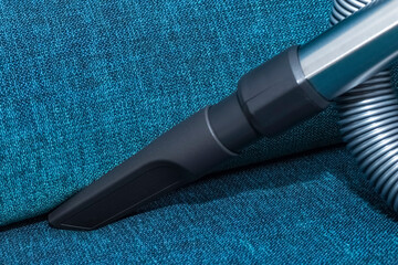 vacuum cleaner nozzle for hard-to-reach places, blue background. Home cleaning