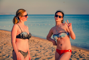 Portrait of mother and podrotsk daughters relaxing chatting on sunny holiday destination beach, outdoors. Family mum and teenager enjoying travel recreation lifestyle