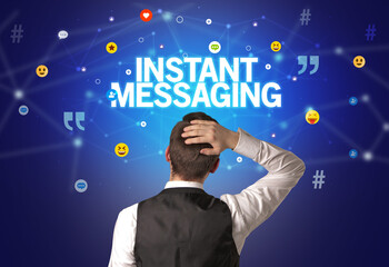 Rear view of a businessman with INSTANT MESSAGING inscription, social networking concept