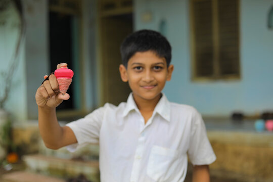 indian child playing with bhovra, Lattu, Bhovra or Bambaram is a traditional throwing top using thread, played mainly in India