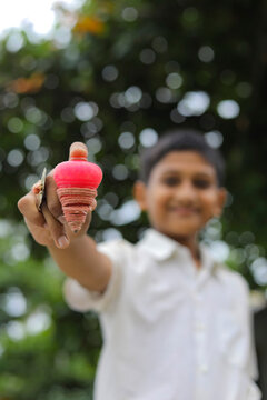 indian child playing with bhovra, Lattu, Bhovra or Bambaram is a traditional throwing top using thread, played mainly in India