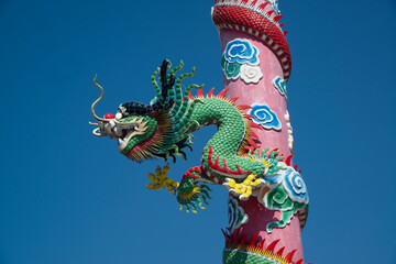 The pillars with stucco dragons wrapped around them are the art of Chinese shrines..