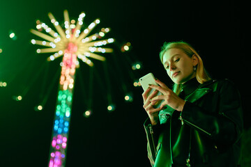 Blond Woman Surf Internet On Smartphone in Amusement Park