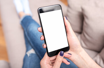 Hands use a smartphone. A smartphone in the hands of a woman who lies on the couch.