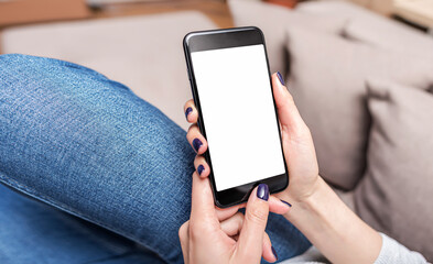 Hands use a smartphone. A smartphone in the hands of a woman who lies on the couch.