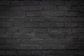 Black color brick wall textured background with vignette at the edge of picture and an empty space for text.