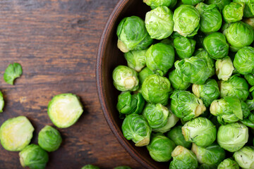 Bunch of fresh Bruxelles sprouts in a cup on wooden background.
