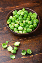 Bunch of fresh Bruxelles sprouts in a cup on wooden background.