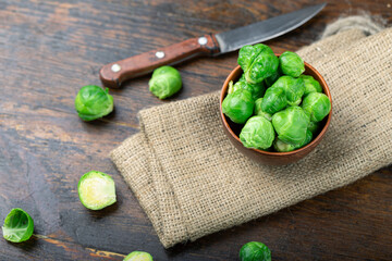 Bunch of fresh Bruxelles sprouts in a cup on wooden background.