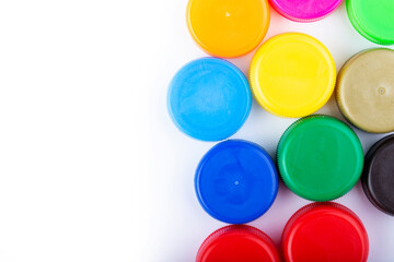 Group of multi colored bottle caps on a white background. Recycling and reuse concept. Space for text.