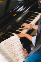 Piano teacher giving piano lesson to a young girl with mask during coronavirus pandemic © Henko Studio