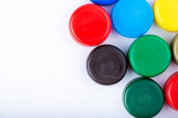 Group of multi colored bottle caps on a white background. Recycling and reuse concept. Space for text.