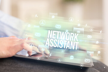 Close-up of a tablet searching NETWORK ASSISTANT inscription, modern technology concept