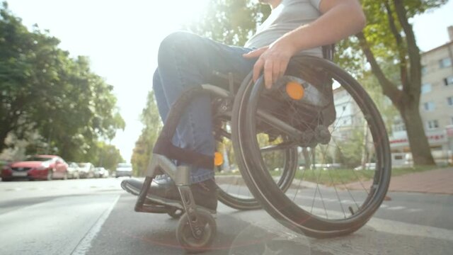 Handicapped man in wheelchair crossing street road