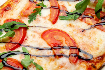Delicious simple pizza with tomatoes, mozzarella and herbs.