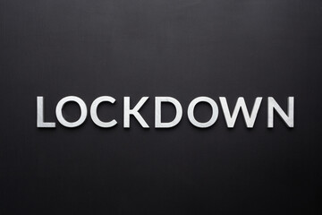 the word lockdown laid with silver metal letters on flat black background in directly above...