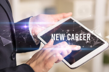 Close up hands using tablet with NEW CAREER inscription, modern business technology concept