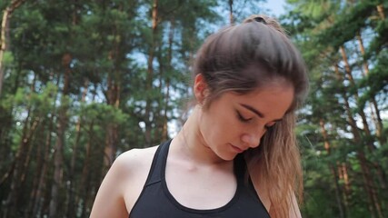woman in black sports outfit doing exercise - neck rotation in the nature
