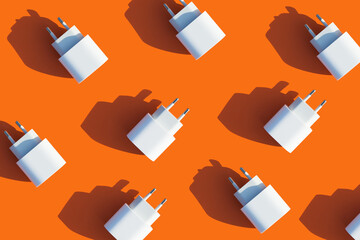 chargers for the phone on a bright background.modern gadgets. orange pattern