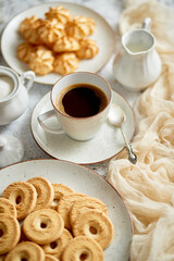 Side view of delicious dessert served. Butter and coconut cookies with cup of black coffee