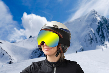 Fototapeta na wymiar Portrait of a woman in a ski helmet and protective reflective goggles against the backdrop of beautiful winter mountains. Sports, recreation and winter sports