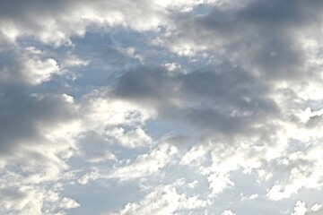 Fototapeta premium Light blue sky with light gray and white clouds in diffused light