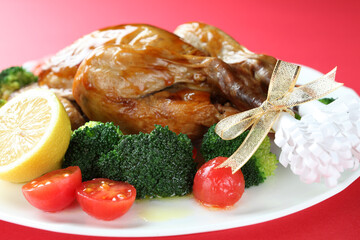 赤いバックで撮影したクリスマスの料理（チキンの丸焼き）