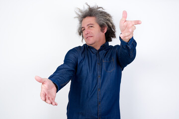 Handsome mature caucasian man with afro grey hair standing over isolated white background looking at the camera smiling with open arms for hug. Cheerful expression embracing happiness.